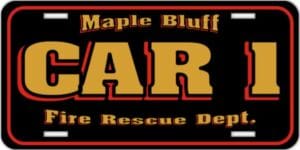 A black license plate with bold gold and red text reading Maple Bluff CAR 1 Fire Rescue Dept.